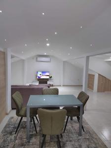 科查尼Anton Lux Apartment的一间带桌椅和电视的用餐室