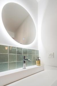 枫丹白露A modern flat in the center of Fontainebleau的一间带水槽和镜子的浴室
