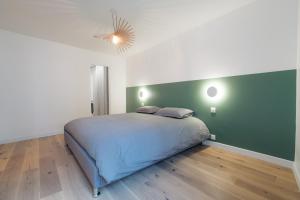 枫丹白露A modern flat in the center of Fontainebleau的一间卧室设有一张床和绿色的墙壁