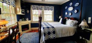 格林维尔柏蒂格鲁住宿加早餐酒店的卧室设有蓝色的墙壁、一张床和一个壁炉