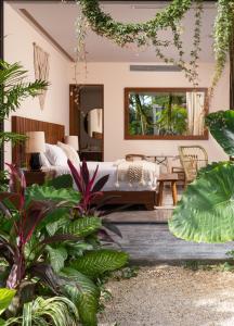 图卢姆MISTIQ Tulum Luxury Apartments的一间卧室,配有床和一些植物