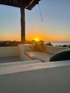 奥尔沃克斯岛Casa Molly的阳台上的一张床,享有海洋上的日落美景