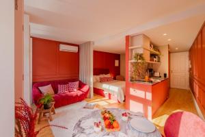 波尔图As Vizinhas Boutique Apartments的客厅配有红色的沙发和床。