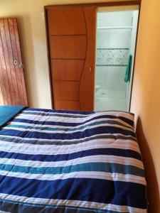 伊克斯雷玛Recanto do Ipê的卧室配有蓝色和白色的床和镜子