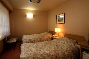 山之内町涩酒店的酒店客房带两张床和电话