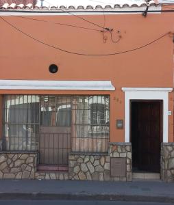 萨尔塔SUMAQ WASICHA SALTA的一座橙色的建筑,设有铁窗和门