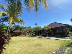 佩母德兰巴厘岛佩母得兰巴迪尼旅馆的一座带庭院和棕榈树的房子