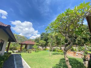 佩母德兰巴厘岛佩母得兰巴迪尼旅馆的一座房子前面有树的花园