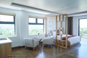 Châu Làng ChánhKhánh Phương Luxury的卧室配有一张床和一张桌子及椅子