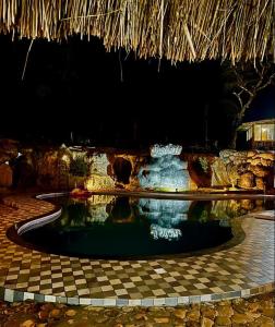 ChegātPugmarks Jungle Lodge的夜间在度假村的游泳池