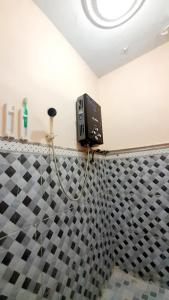 迪昂Homestay Merpati Dieng Syariah RedPartner的浴室设有 ⁇ 板瓷砖墙和肥皂机