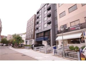 金泽HOTEL APT SESELA - Vacation STAY 12884的街道前有停车位的建筑物