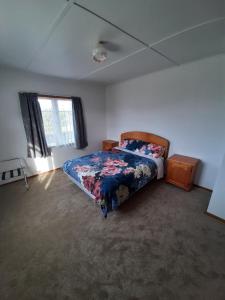 奥波蒂基Mary's Place的一间卧室配有一张带花卉棉被的床