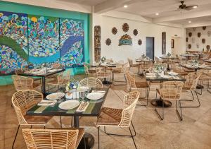 科隆Tag Resort的用餐室配有桌椅和壁画