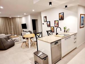 玛志洛Maroochy City Lights@Thecosmopolitan Unit 20802的厨房以及带沙发和桌子的客厅。