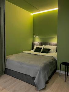 赫梅利尼茨基Апартаменти-студія, дизайнерський ремонт, ЦЕНТР, біля ТРК "Либідь Плаза"的一间卧室设有一张带绿色墙壁的大床