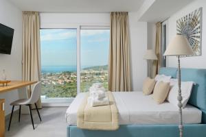 萨索斯Kefi Luxury Villas的酒店客房设有一张床和一个大窗户
