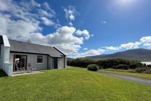 Achill SoundAchill Sound Holiday Village No 11的一座房子,旁边是草地庭院