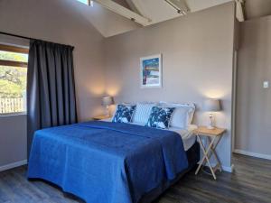 钦查HERON COTTAGE - for your seaside holiday.的一间卧室设有蓝色的床和窗户。