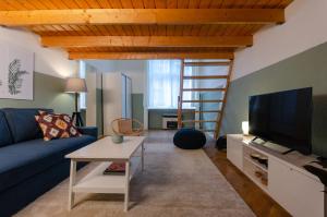 布达佩斯COSY APARTMENT IN CENTRAL DISTRICT.的客厅配有蓝色的沙发和电视