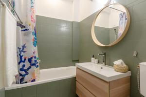 布达佩斯COSY APARTMENT IN CENTRAL DISTRICT.的一间带水槽、浴缸和镜子的浴室