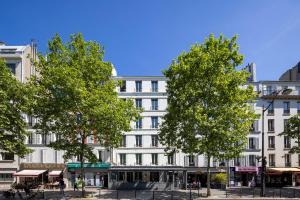 巴黎Hôtel Nude Paris - Color Vision的前面有树木的白色建筑
