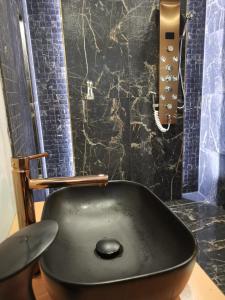 斯拉瓦APARTAMENT NAD JEZIOREM的带淋浴的浴室内的黑水槽