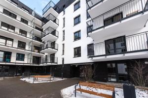 华沙Project Comfort Apartament Potrzebna 55/130 Warszawa的前面有两长椅的建筑