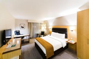 布伦特福德假日伦敦布伦特福德湖酒店的酒店客房设有一张大床和一张书桌。