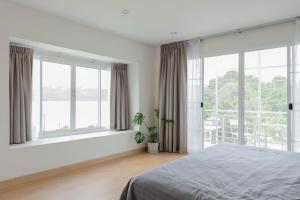 帕夭PB Place @ Kwan Payao的卧室拥有白色的墙壁和窗户,配有一张床