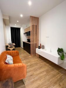 贝济耶Suite cocooning & spa的客厅配有橙色沙发和桌子
