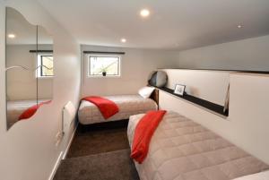 但尼丁City Views on Rattray的一间小卧室,配有两张床和镜子