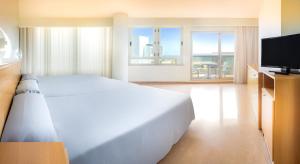 甘迪亚Hotel RH Gijón & Spa的卧室配有一张白色大床和一台平面电视。