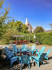 Beaulieu-lès-LochesLe Grand Presbytère de Beaulieu的一组蓝色椅子和一张桌子,放在院子里