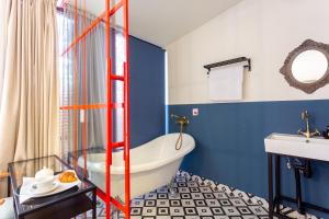 第比利斯Shota Rustaveli Aparthotel的浴室设有白色浴缸和蓝色的墙壁。