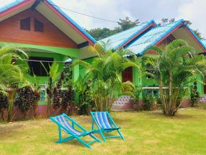 象岛Papaya Cottage Koh Chang的两把蓝色椅子坐在房子前面