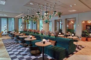 斯德哥尔摩斯堪迪克公园酒店的餐厅设有绿色的沙发和桌椅
