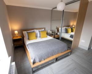 巴洛赫Westertonhill Lodge 3 with Hot Tub Option的一间卧室配有一张带黄色枕头和镜子的床