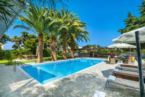 波利克罗诺Albero Villa Polychrono的度假村内棕榈树游泳池