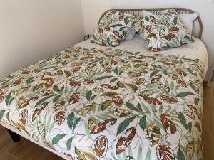 Le Clos des Embruns的一张带五颜六色的被子和两个枕头的床