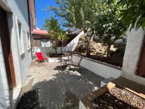 科英布拉Moradia com Alma Xico's House的一个带椅子和桌子的庭院和一棵树