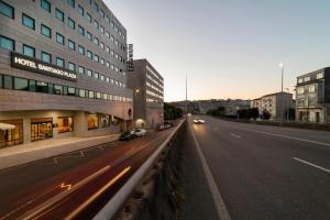 圣地亚哥－德孔波斯特拉Hotel Santiago Plaza Affiliated by Meliá的一条空荡荡荡的城市街道,路边有建筑物和汽车