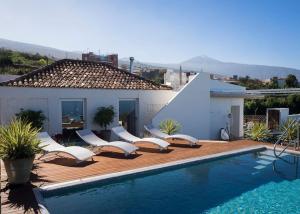 拉奥罗塔瓦Casa Viña: a spectacular away from it all holiday的一个带白色椅子的游泳池以及一座房子