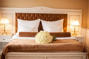伊万诺-弗兰科夫斯克纳迪亚酒店的一间卧室配有一张带鲜花的大床