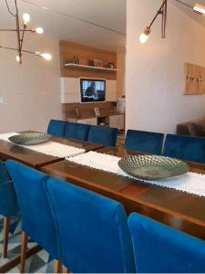 圣若阿金Apê aconchegante e quentinho em São Joaquim的一张带蓝色椅子的餐桌和一台电视