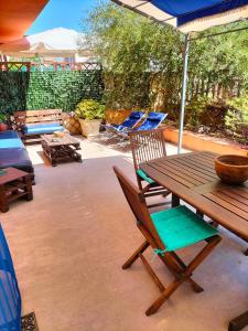 瓦雷多利亚Appartamento in villa的庭院配有木桌、椅子和遮阳伞。