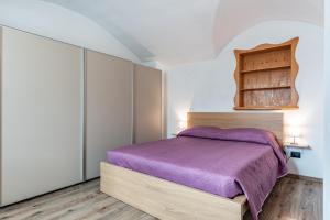 佩尔吉内瓦尔苏加纳Residenza Glicine的一间卧室配有一张紫色的床和一个橱柜