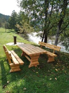亚伊采Studio by the river的河边的木餐桌和长凳