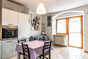 佩尔吉内瓦尔苏加纳Residenza Glicine的厨房以及带粉红色桌椅的用餐室。