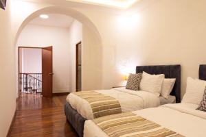 基多Suites Experience by Hotel David的一间带两张床的卧室和一个拱门